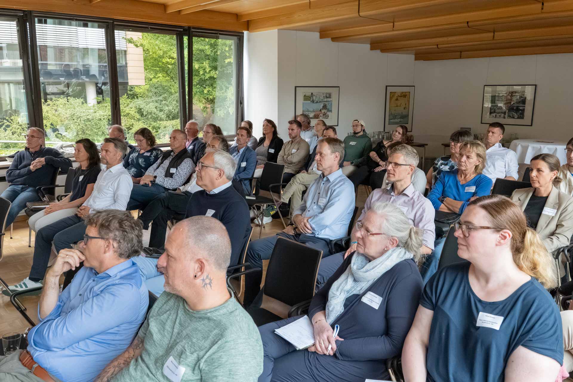 viele Interessierte Personen in Stuhlreihen schauen in Richtung des Rednerpults